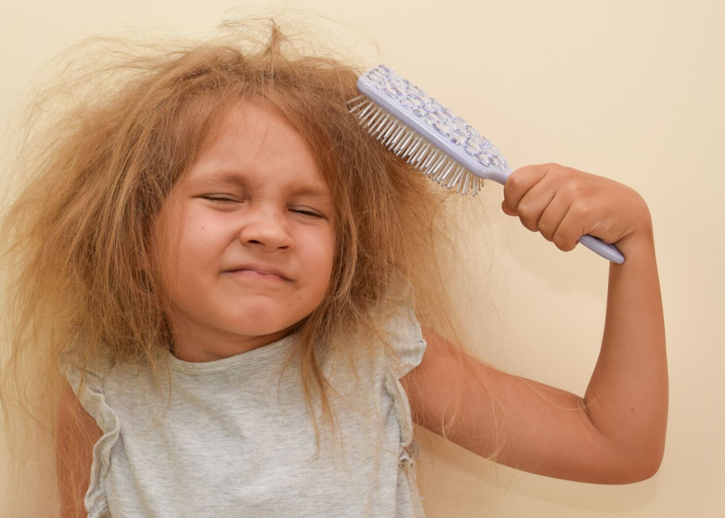 Ein Mädchen kämmt ihre zersausten Haare