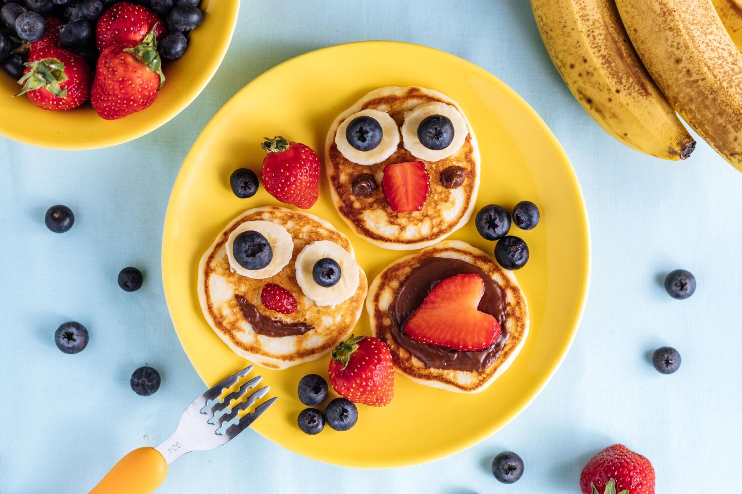 Selbstgemachte Pancakes mit Obst und Schokolade lustig dekoriert